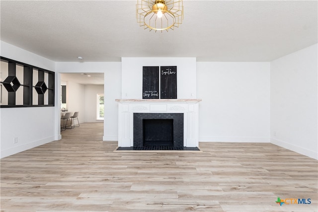 unfurnished living room featuring light hardwood / wood-style flooring and a textured ceiling