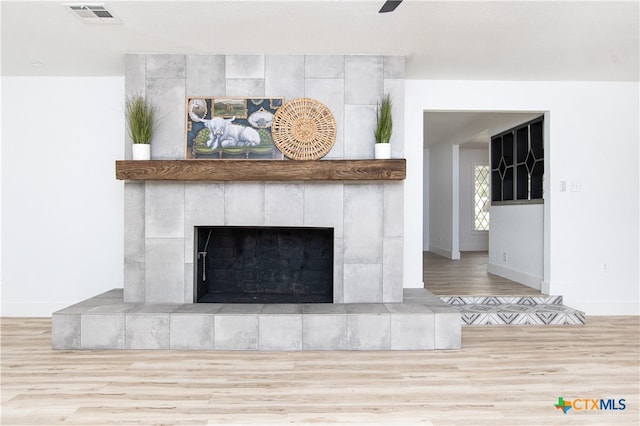 room details with hardwood / wood-style floors and a tiled fireplace