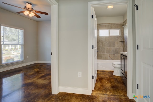 full bathroom featuring concrete floors, ceiling fan, vanity, toilet, and tiled shower / bath combo