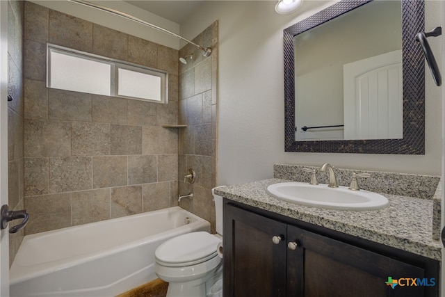 full bathroom with toilet, vanity, and tiled shower / bath