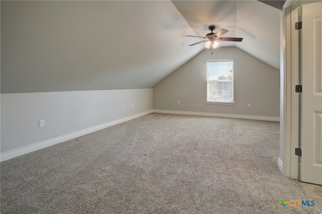 additional living space featuring ceiling fan, light colored carpet, and vaulted ceiling