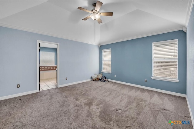 carpeted spare room featuring crown molding, lofted ceiling, and ceiling fan