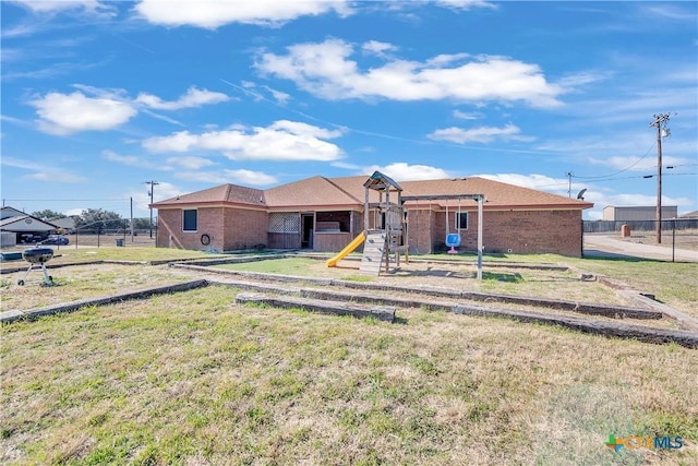 view of front of home featuring a front yard and a playground