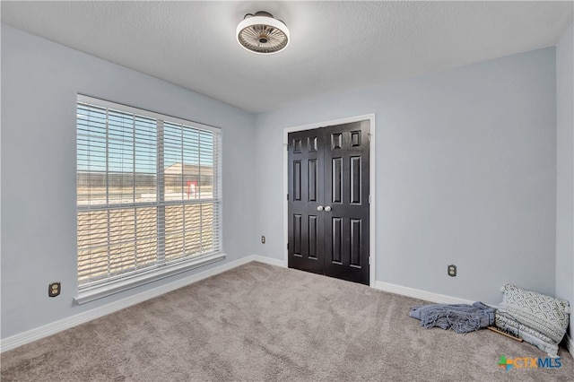 unfurnished bedroom featuring carpet and a textured ceiling