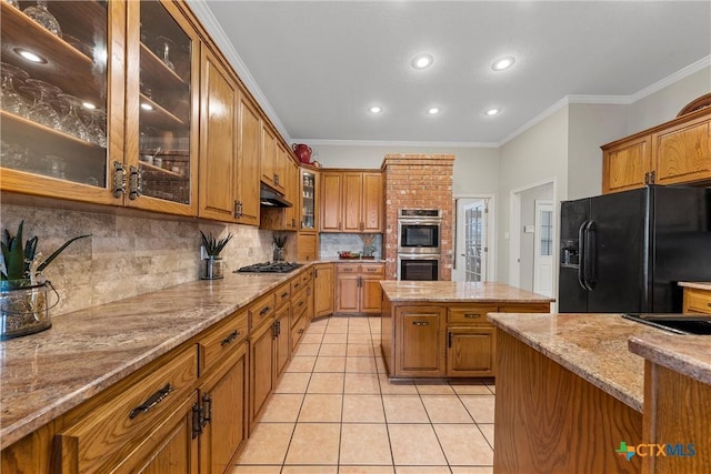 kitchen with light tile patterned floors, crown molding, stainless steel appliances, a center island, and light stone countertops