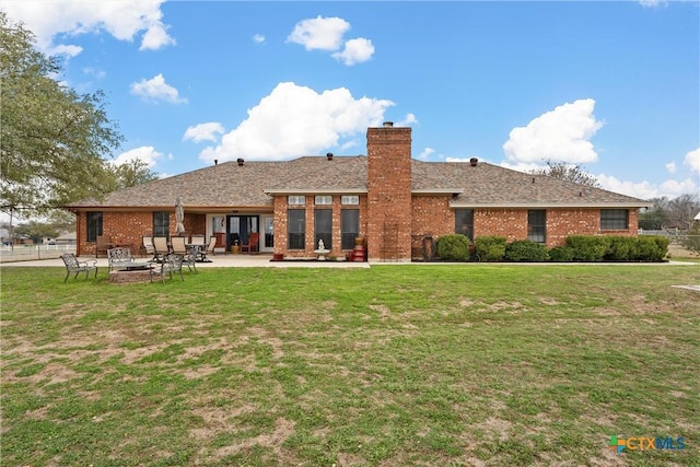 back of property featuring a lawn and a patio