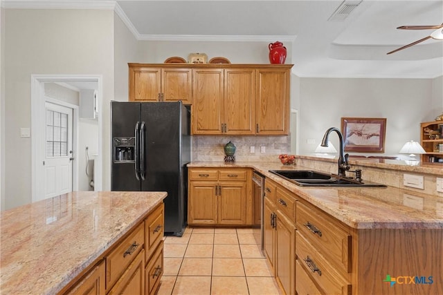 kitchen featuring sink, light tile patterned floors, ceiling fan, light stone countertops, and black fridge