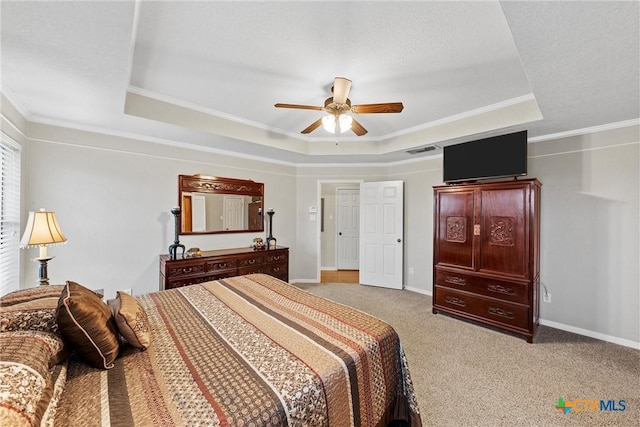 bedroom featuring crown molding, a tray ceiling, and light colored carpet