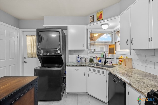 kitchen with black dishwasher, stacked washer and dryer, and white cabinets