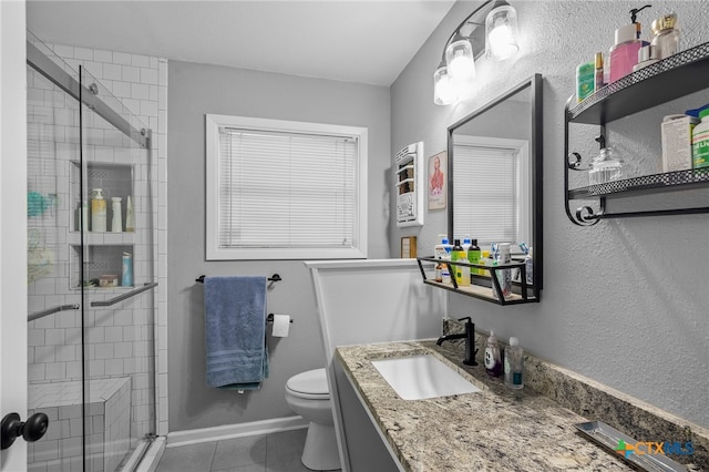 bathroom featuring vanity, a shower with shower door, tile patterned flooring, and toilet