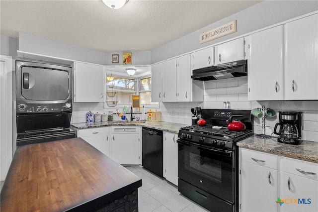 kitchen featuring black appliances, stacked washing maching and dryer, sink, and white cabinets