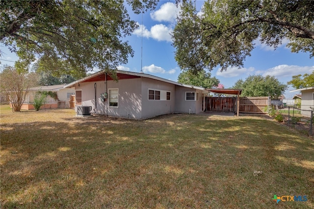 back of property with central AC and a yard