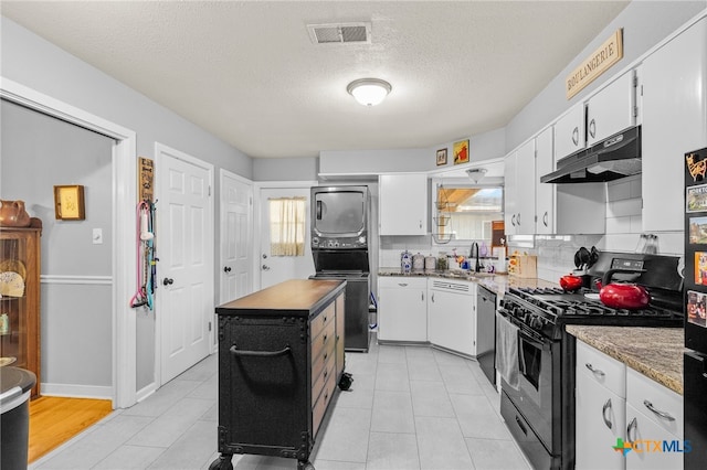 kitchen featuring decorative backsplash, a textured ceiling, a kitchen island, white cabinetry, and appliances with stainless steel finishes