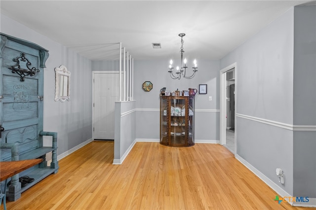 dining area with light hardwood / wood-style flooring and an inviting chandelier