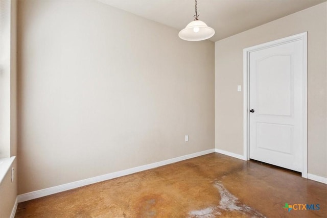 spare room featuring concrete floors and baseboards