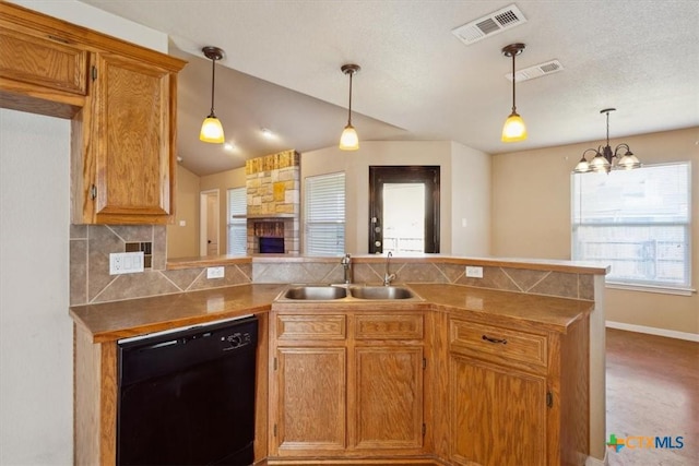 kitchen featuring visible vents, backsplash, dishwasher, a peninsula, and a sink