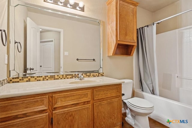 bathroom with tasteful backsplash, shower / bath combo with shower curtain, toilet, and vanity