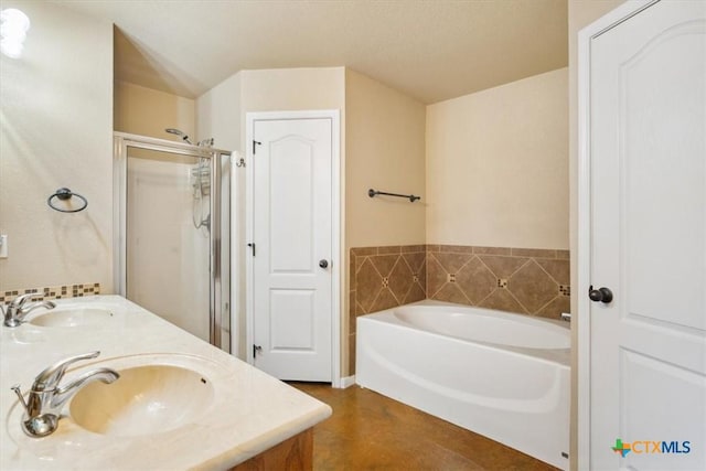 bathroom featuring double vanity, a stall shower, a garden tub, and a sink