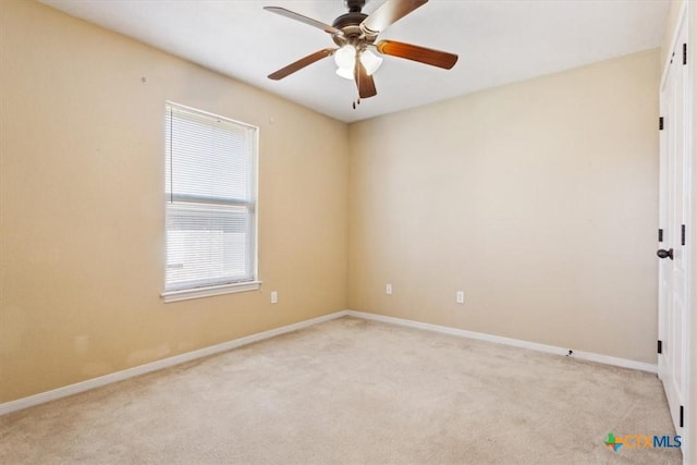 empty room with light colored carpet, baseboards, and ceiling fan