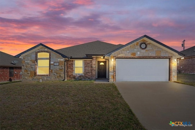 single story home featuring stone siding, an attached garage, concrete driveway, and a yard