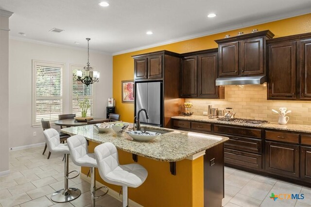 9550 Savannah Ridge Dr Unit 11, Austin, TX 78726 - kitchen featuring appliances with stainless steel finishes, under cabinet range hood, a sink, light stone counters, and tasteful backsplash