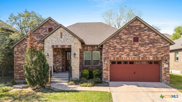9550 Savannah Ridge Dr Unit 11, Austin, TX 78726 - view of front of home featuring driveway, brick siding, and a shingled roof