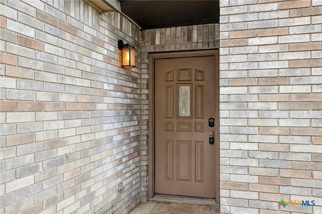 doorway to property featuring a shingled roof