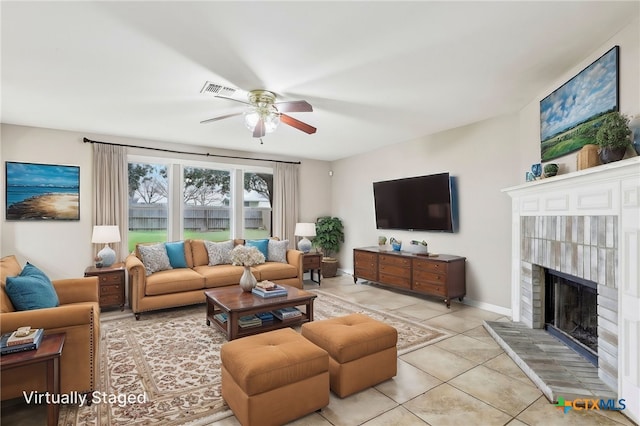 tiled living room with a ceiling fan, visible vents, and a fireplace