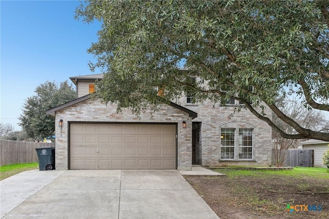 view of front facade with an attached garage, fence, concrete driveway, and brick siding