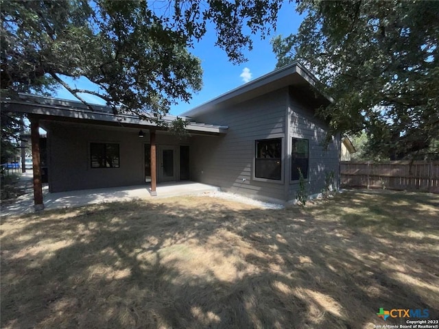 back of property with a patio area and fence