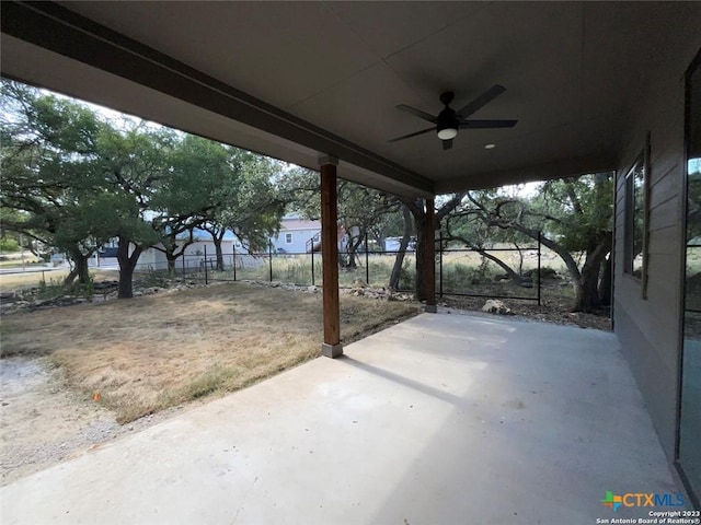 view of patio featuring ceiling fan, a carport, and fence