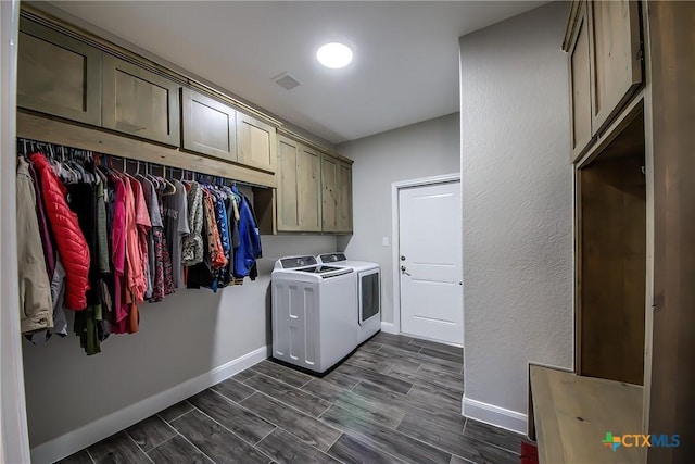 laundry area featuring separate washer and dryer and cabinets