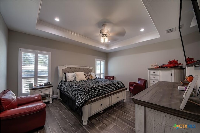 bedroom featuring ceiling fan and a raised ceiling