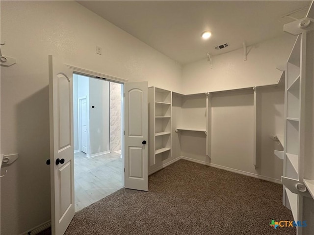 spacious closet featuring dark carpet