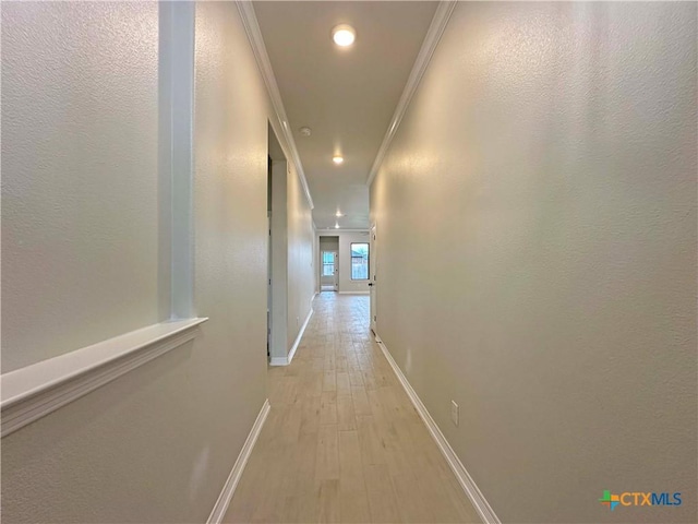 hall featuring ornamental molding and light hardwood / wood-style floors