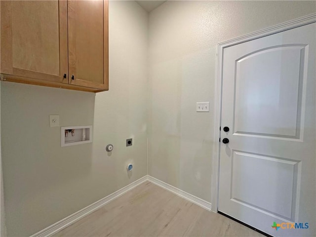 laundry area featuring cabinets, hookup for a gas dryer, hookup for a washing machine, electric dryer hookup, and light hardwood / wood-style flooring