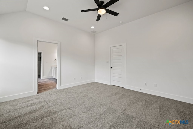 empty room featuring lofted ceiling, ceiling fan, and carpet floors