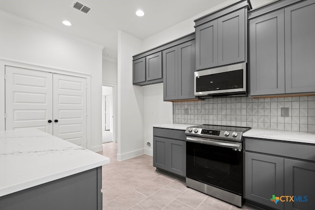 kitchen with gray cabinets, stainless steel appliances, and backsplash