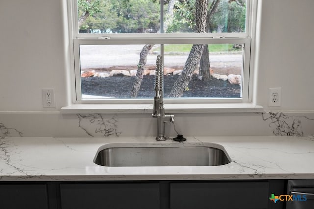 room details featuring light stone countertops, sink, and backsplash