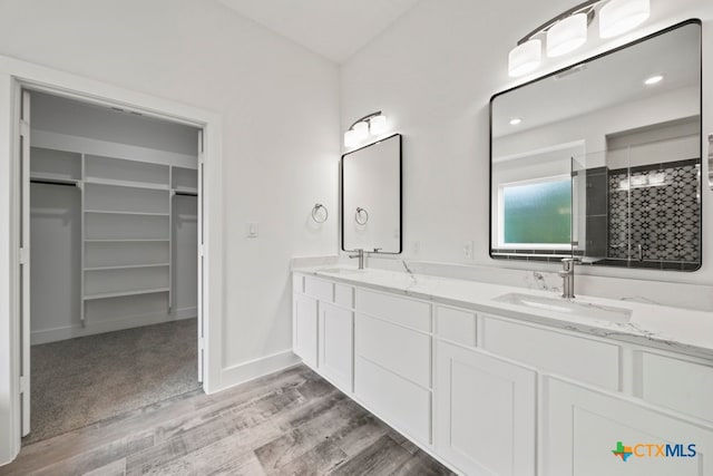 bathroom with hardwood / wood-style floors, vanity, and a shower