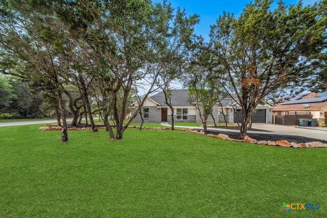 ranch-style home with a garage and a front yard