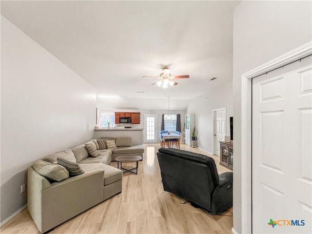 144 Calcite Ln, Jarrell, TX 76537 - living area featuring a ceiling fan, light wood-style floors, and baseboards