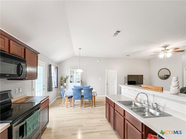 144 Calcite Ln, Jarrell, TX 76537 - kitchen featuring black microwave, stainless steel range with electric cooktop, a sink, open floor plan, and vaulted ceiling