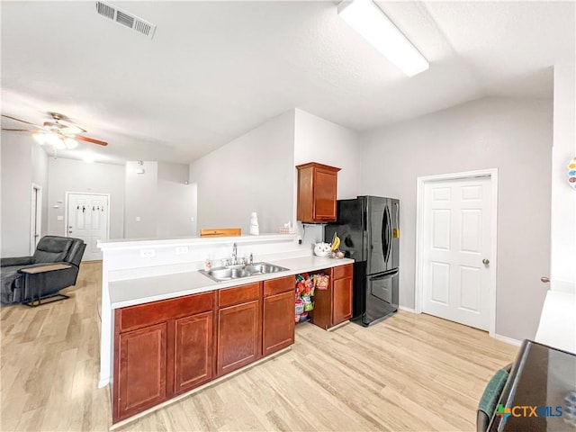 144 Calcite Ln, Jarrell, TX 76537 - kitchen featuring freestanding refrigerator, a sink, light wood finished floors, a peninsula, and a ceiling fan