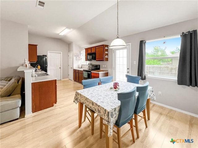 144 Calcite Ln, Jarrell, TX 76537 - dining room with light wood-type flooring, lofted ceiling, and baseboards