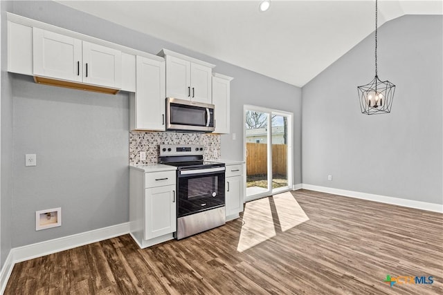 kitchen with lofted ceiling, dark wood-style floors, stainless steel appliances, light countertops, and white cabinetry