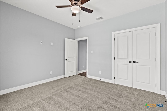 unfurnished bedroom with carpet floors, a closet, visible vents, ceiling fan, and baseboards