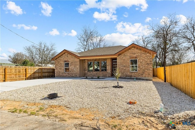 view of front of home with brick siding and a fenced backyard