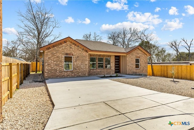 view of front facade featuring fence private yard and brick siding