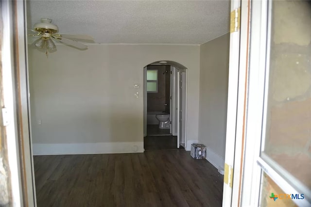 unfurnished room featuring ceiling fan, dark hardwood / wood-style floors, a textured ceiling, and crown molding